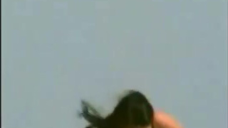 Two lesbians oil each other topless at the beach