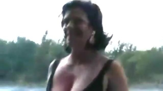 Amateur MILF strips nude by the river